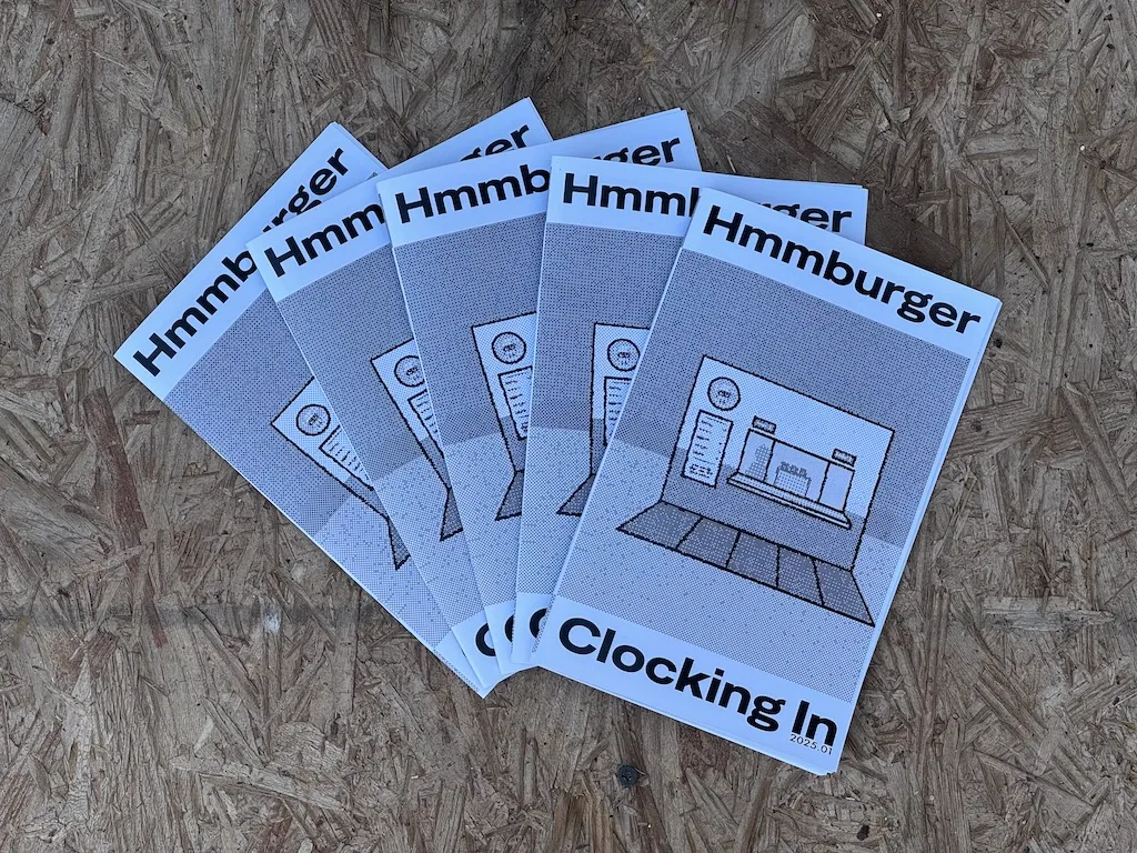 Printed versions of Clocking In fanned out on some particle board.